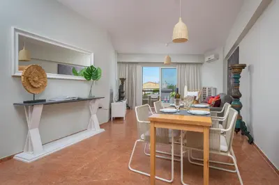 a dining room and living room with a table and chairs at Melita City Apartment in Rhodes Town