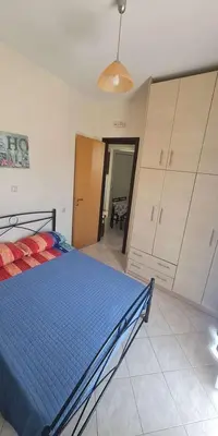 a bedroom with a blue bed and some cabinets at Retas apartment in Kremasti