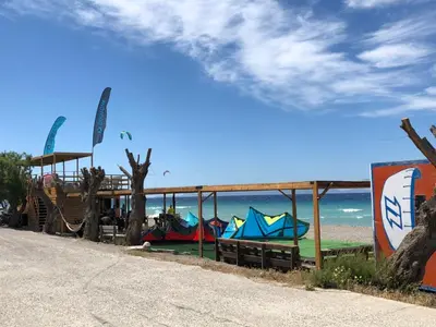 a building with kites on the beach next to the ocean at Retas apartment in Kremasti