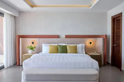 a bedroom with a large bed with yellow and green pillows at Boutique 5 Hotel & Spa - Adults Only in Kiotari