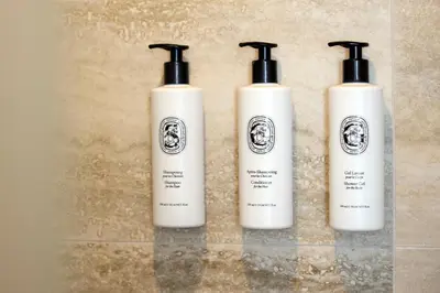three white shampoo bottles sitting on top of a counter at Boutique 5 Hotel & Spa - Adults Only in Kiotari