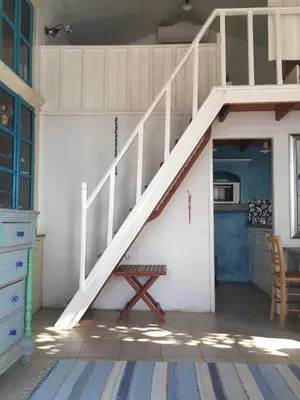 a staircase in a room with a table and a bench at Plesner House, Symi Greece in Symi