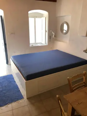 a bed in a room with a blue mattress at Plesner House, Symi Greece in Symi
