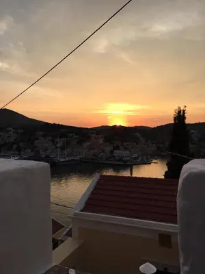 a view of the sunset from the balcony of a house at Plesner House, Symi Greece in Symi