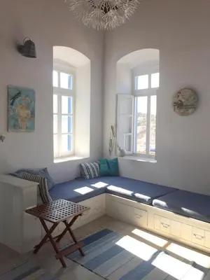 a room with a blue bench and two windows at Plesner House, Symi Greece in Symi