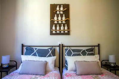 a bedroom with two beds and a shelf with shoes at Aramis Boutique House in Rhodes Town