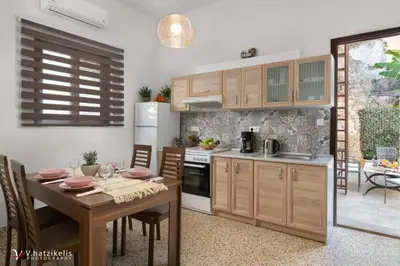 a kitchen with a wooden table and a dining room at Aramis Boutique House in Rhodes Town