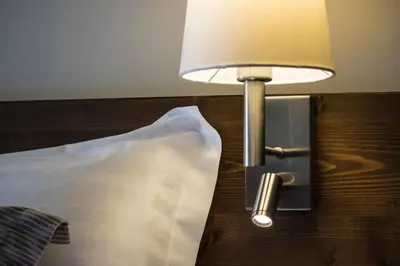 a lamp on the side of a bed with a pillow at D'Argento Boutique Rooms in Rhodes Town