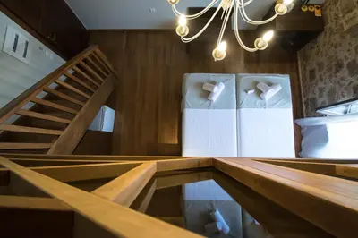 a room with a staircase and two white chairs at D'Argento Boutique Rooms in Rhodes Town