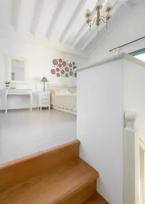 a white bedroom with a bed and a desk at Aegli Villa by Blue Wave in Symi