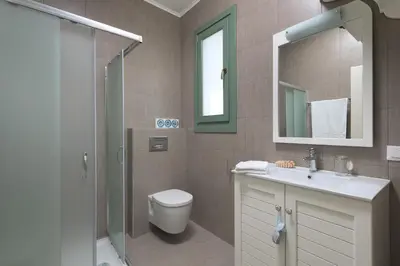 a bathroom with a toilet and a sink and a shower at Aegli Villa by Blue Wave in Symi