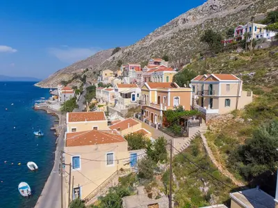 a group of houses on a hill next to the water at Aegli Villa by Blue Wave in Symi