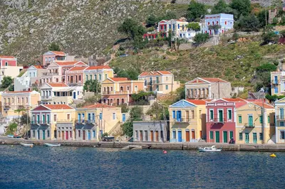 a group of houses on a hill next to the water at Aegli Villa by Blue Wave in Symi