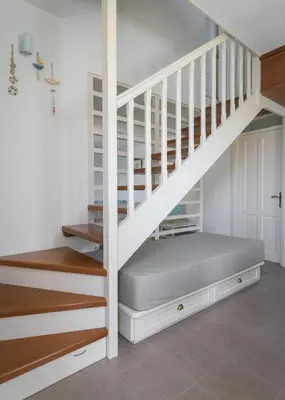 a bedroom with a bed under the stairs at Aegli Villa by Blue Wave in Symi