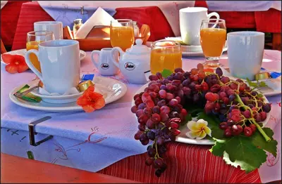 a table with a plate of grapes and cups and juice at Kalathos Sun Hotel in Kalathos