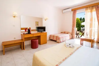 a hotel room with a bedroom with a bed and a desk at Stavros Melathron Studios in Kallithea Rhodes