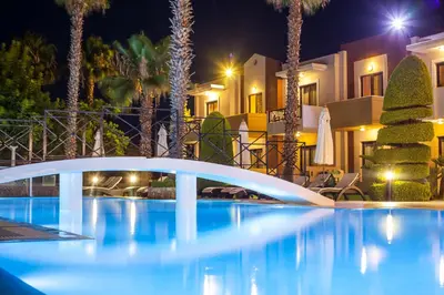 a swimming pool at night with a white bridge at Stavros Melathron Studios in Kallithea Rhodes