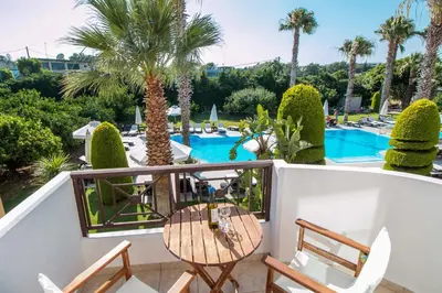 a balcony with a table and chairs and a swimming pool at Stavros Melathron Studios in Kallithea Rhodes