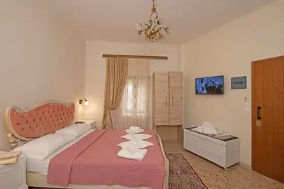 a bedroom with a pink bed with towels on it at Arionos Rooms - Old Town in Rhodes Town