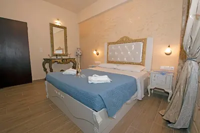 a bedroom with a bed with a blue comforter and a mirror at Arionos Rooms - Old Town in Rhodes Town