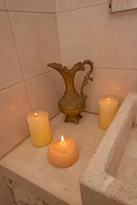 three candles are sitting on a counter in a bathroom at Arionos Rooms - Old Town in Rhodes Town