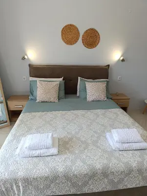 a bedroom with a large bed with two pillows at Agathi Paradise Studios in Haraki