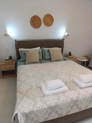 a bedroom with a large bed with two towels on it at Agathi Paradise Studios in Haraki