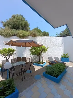 a patio with a table with an umbrella and chairs at Agathi Paradise Studios in Haraki