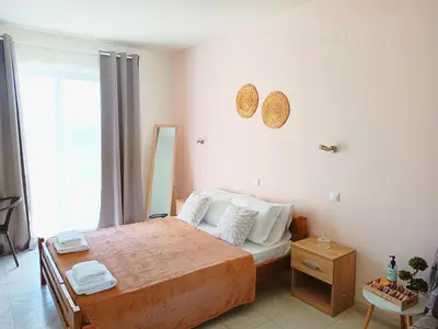 a bedroom with a bed and a large window at Agathi Paradise Studios in Haraki