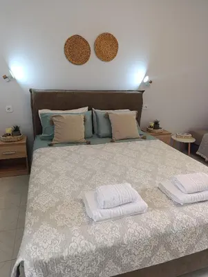 a bedroom with a large bed with two towels on it at Agathi Paradise Studios in Haraki