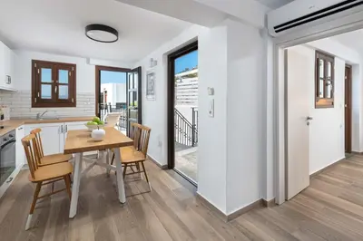 a kitchen and dining room with a table and chairs at Lindos Heart Apartments in Líndos