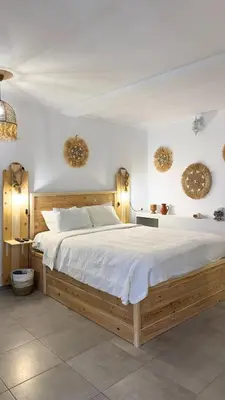 a bedroom with a large bed and two mirrors on the wall at Peters Studio in Archangelos