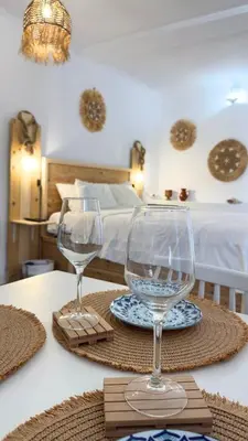 two wine glasses sitting on a table in a bedroom at Peters Studio in Archangelos