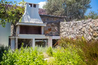 an old building with a stone wall and weeds at Villa Helios in Kalathos