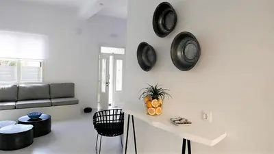 a white living room with black clocks on the wall at 30villa Rd in Rhodes Town
