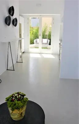 a white living room with a bowl of flowers on a table at 30villa Rd in Rhodes Town
