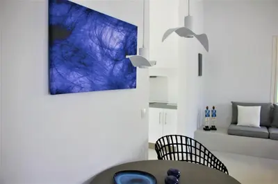 a dining room with a table and a blue painting on the wall at 30villa Rd in Rhodes Town