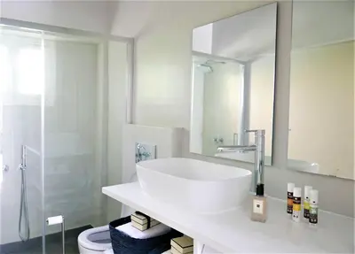 a white bathroom with a sink and a mirror at 30villa Rd in Rhodes Town