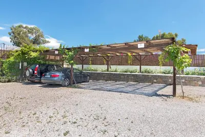 two cars parked under a wooden pergola at Horizon Line Villas in Kiotari