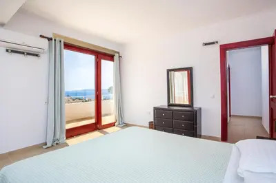 a bedroom with a bed and a mirror and a window at Spilia Bay Villas in Pefki Rhodes