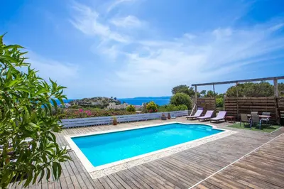 a swimming pool on a deck with a view of the ocean at Spilia Bay Villas in Pefki Rhodes
