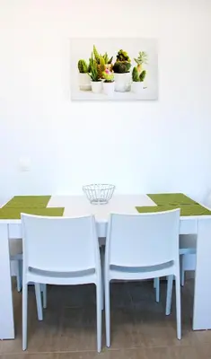 a white dining room table with two chairs and plants at Gennadi Gardens exclusive apartments in Gennadi