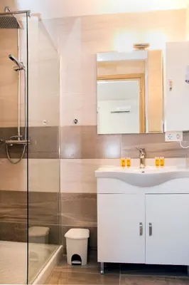 a bathroom with a sink and a shower at Gennadi Gardens exclusive apartments in Gennadi