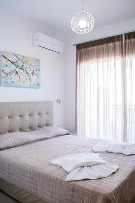 a bedroom with a large bed and a window at Gennadi Gardens exclusive apartments in Gennadi