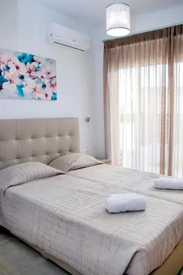 a bedroom with a large bed with two pillows on it at Gennadi Gardens exclusive apartments in Gennadi