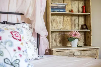a bedroom with a bed and a table with a vase of flowers at Sunny Countryside Villa - With private pool in Faliraki