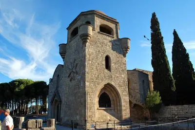 a stone building with a tower on top of it at Vivian Studios in Ialyssos
