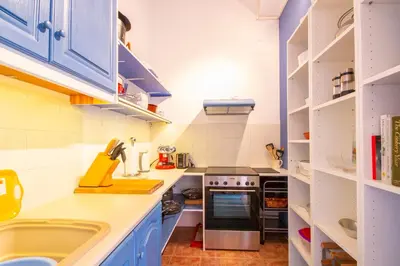 a small kitchen with blue cabinets and a sink at Villa Galanis in Symi