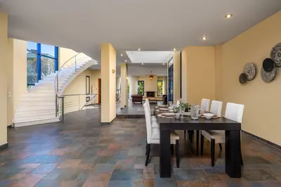 a dining room with a table and white chairs at Themis Private Villa Rhodes in Ialyssos