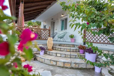 a patio with flowers and potted plants on a house at Ktima Argyrou Stegna in Archangelos